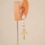 Gold-tone baroque pearl chandelier earring on an ear display