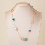 Turquoise and baroque pearl necklace displayed on a bust