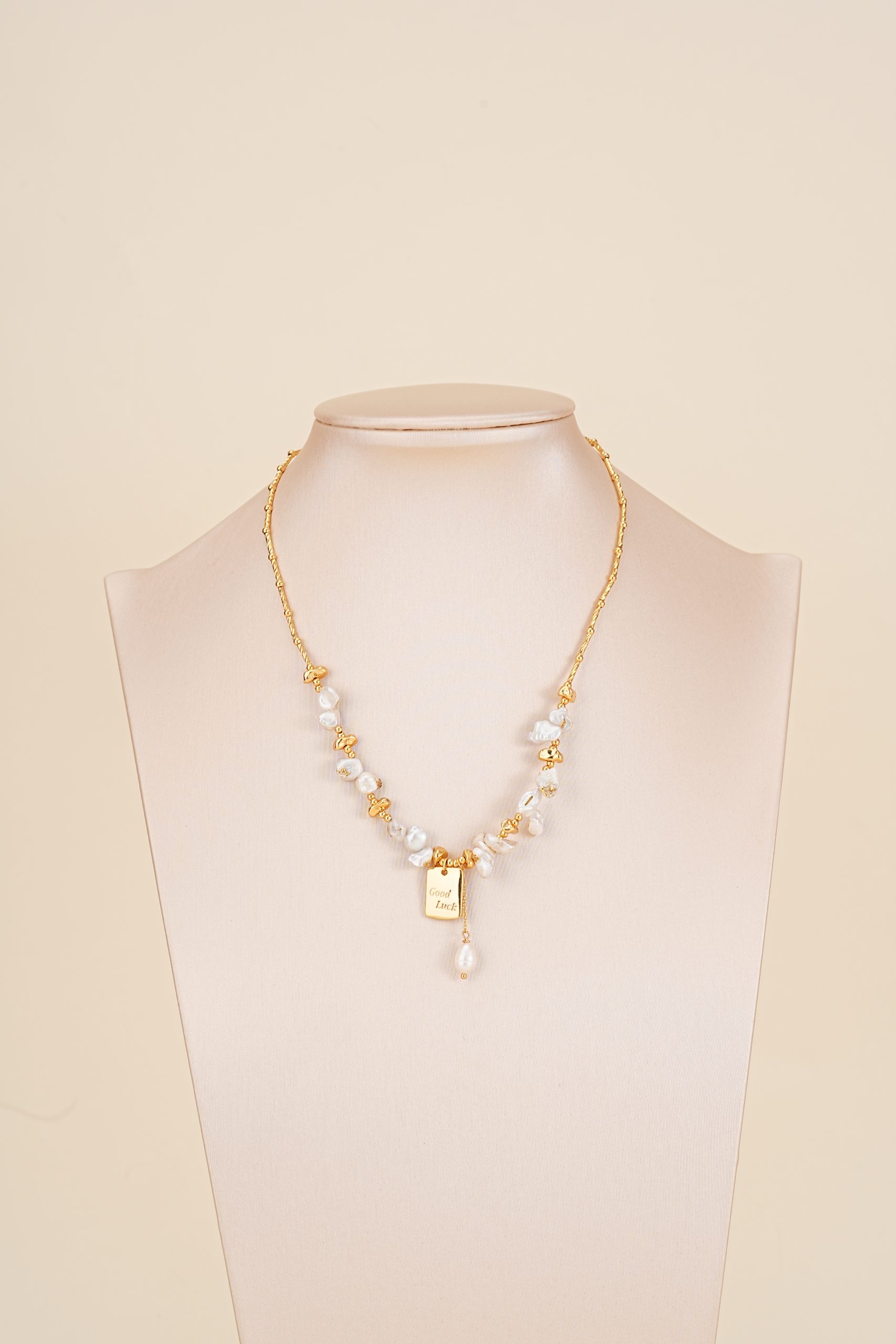Good Luck baroque pearl charm necklace displayed on a bust