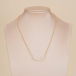 Eight-pearl gold-tone necklace displayed on a bust