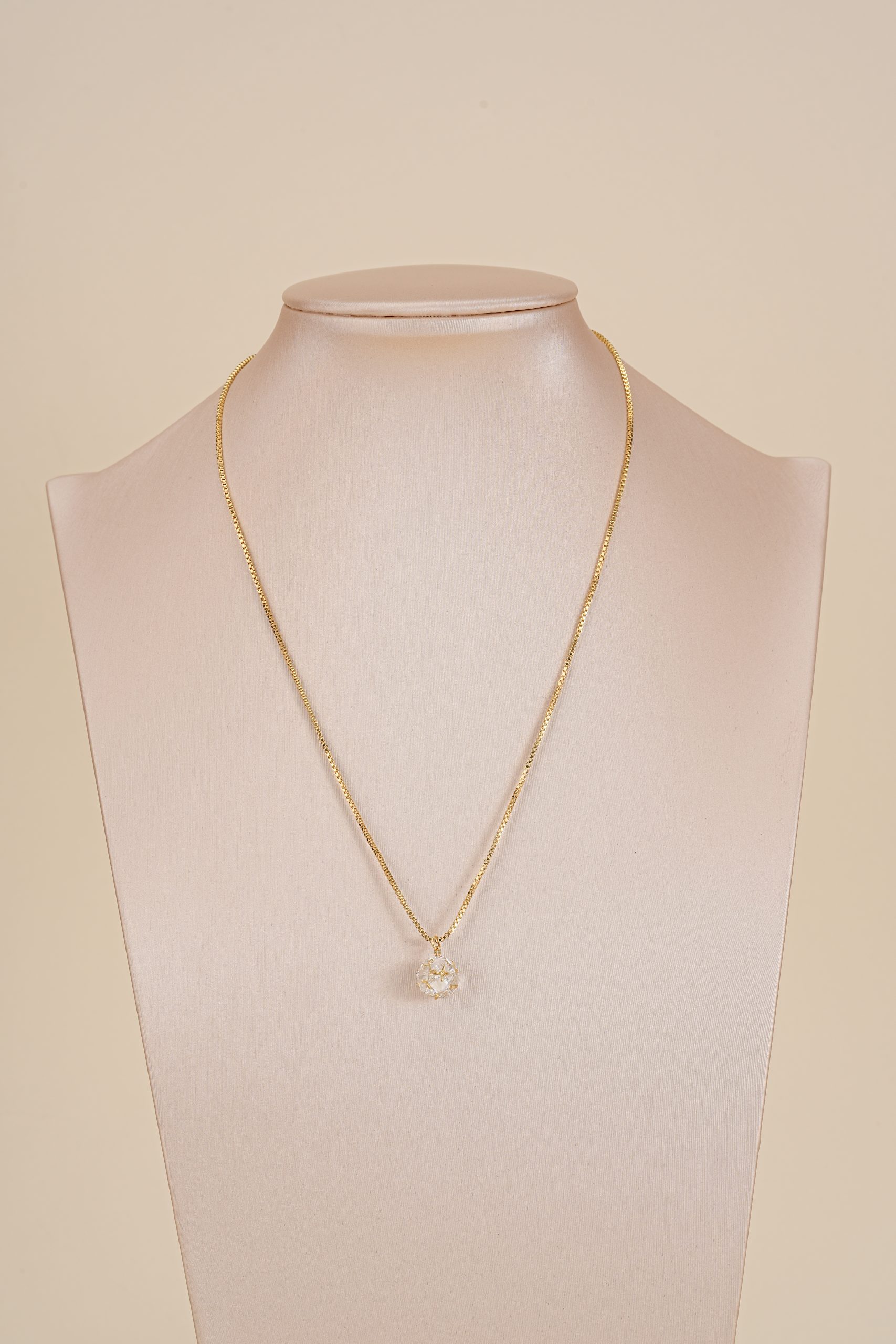 Long crystal pendant necklace displayed on a jewelry bust