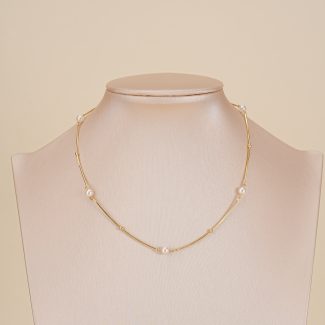 Short pearl-spaced necklace displayed on a jewelry bust