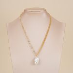 Asymmetric baroque pearl pendant necklace displayed on a jewelry bust