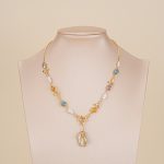 Multicolor baroque pearl pendant necklace displayed on a bust