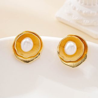 Front view of sculptural golden flower studs with central pearls
