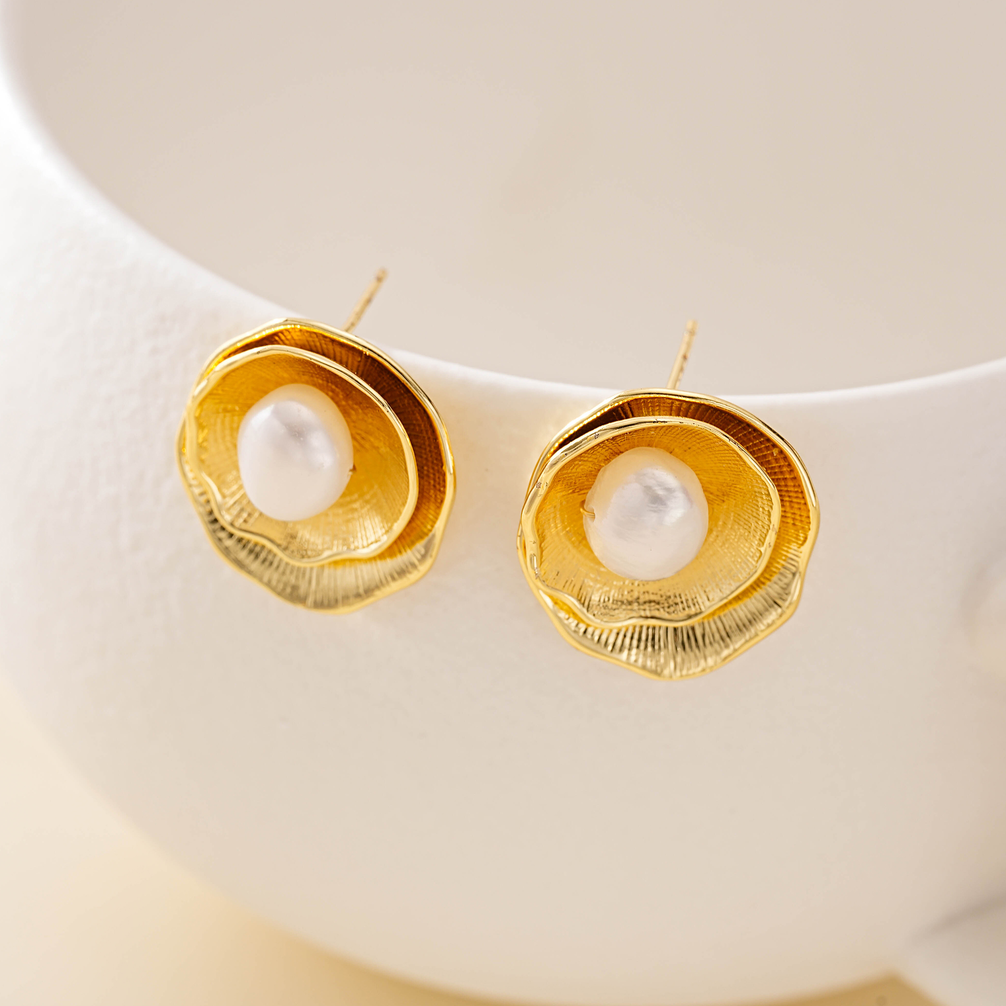 Layered gold-toned petal stud earrings with freshwater pearl centers