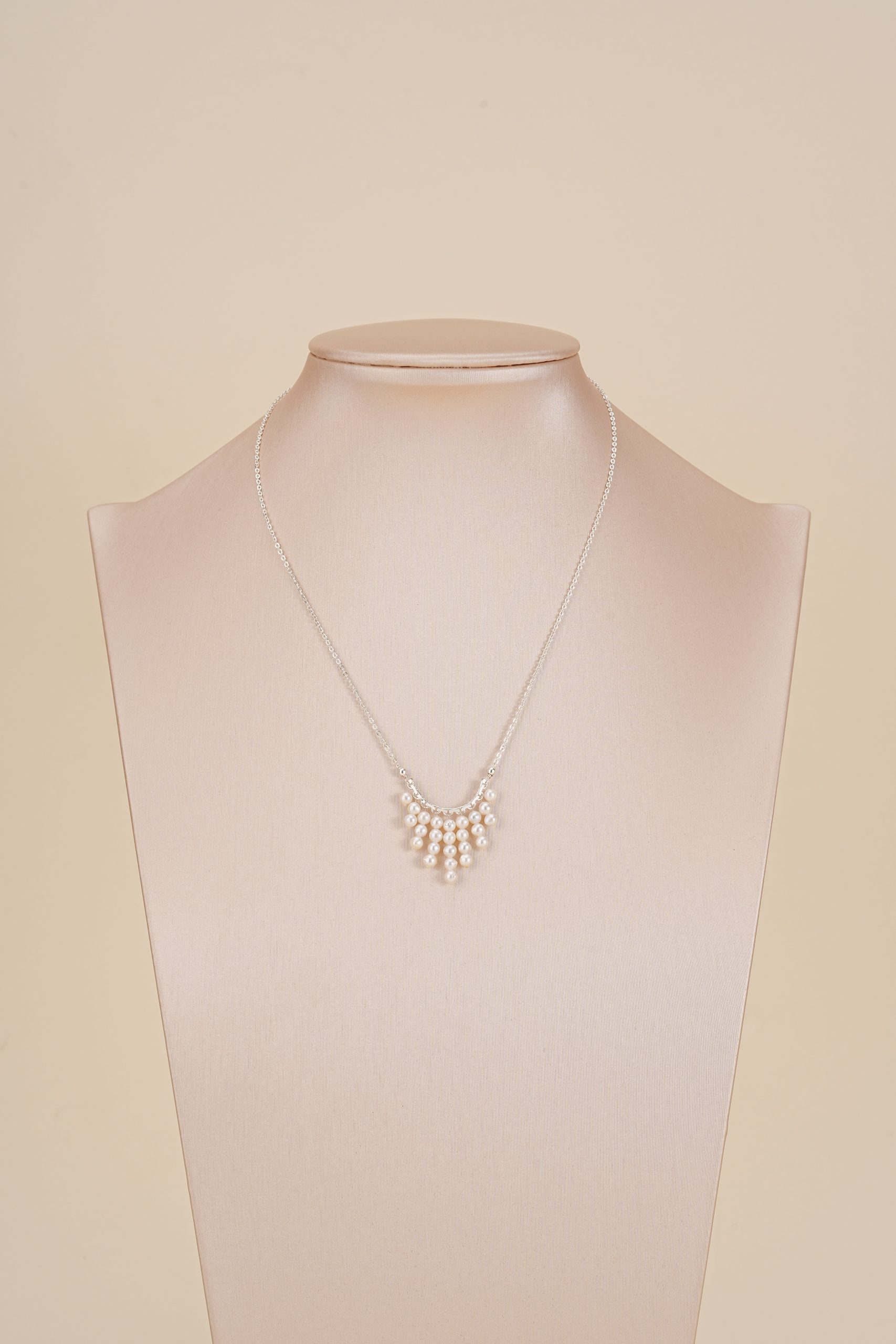 Nine-strand freshwater pearl necklace displayed on a neutral bust
