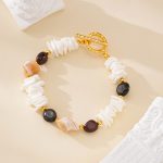 Angled view of mixed shell and tiger eye bracelet with gold-toned toggle