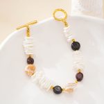 Full view of shell and tiger eye bracelet on a cream dish