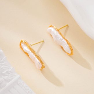 Elongated baroque pearl stud earrings in delicate gold-toned outlines