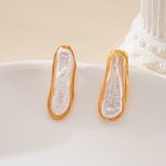 Front view of matching long pearl outline stud earrings