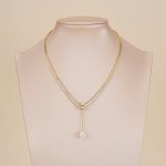 Gold-tone pearl drop snake chain necklace displayed on a jewelry bust
