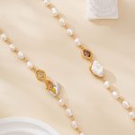 Close-up of freshwater pearls with violet, clear and gold-toned accents