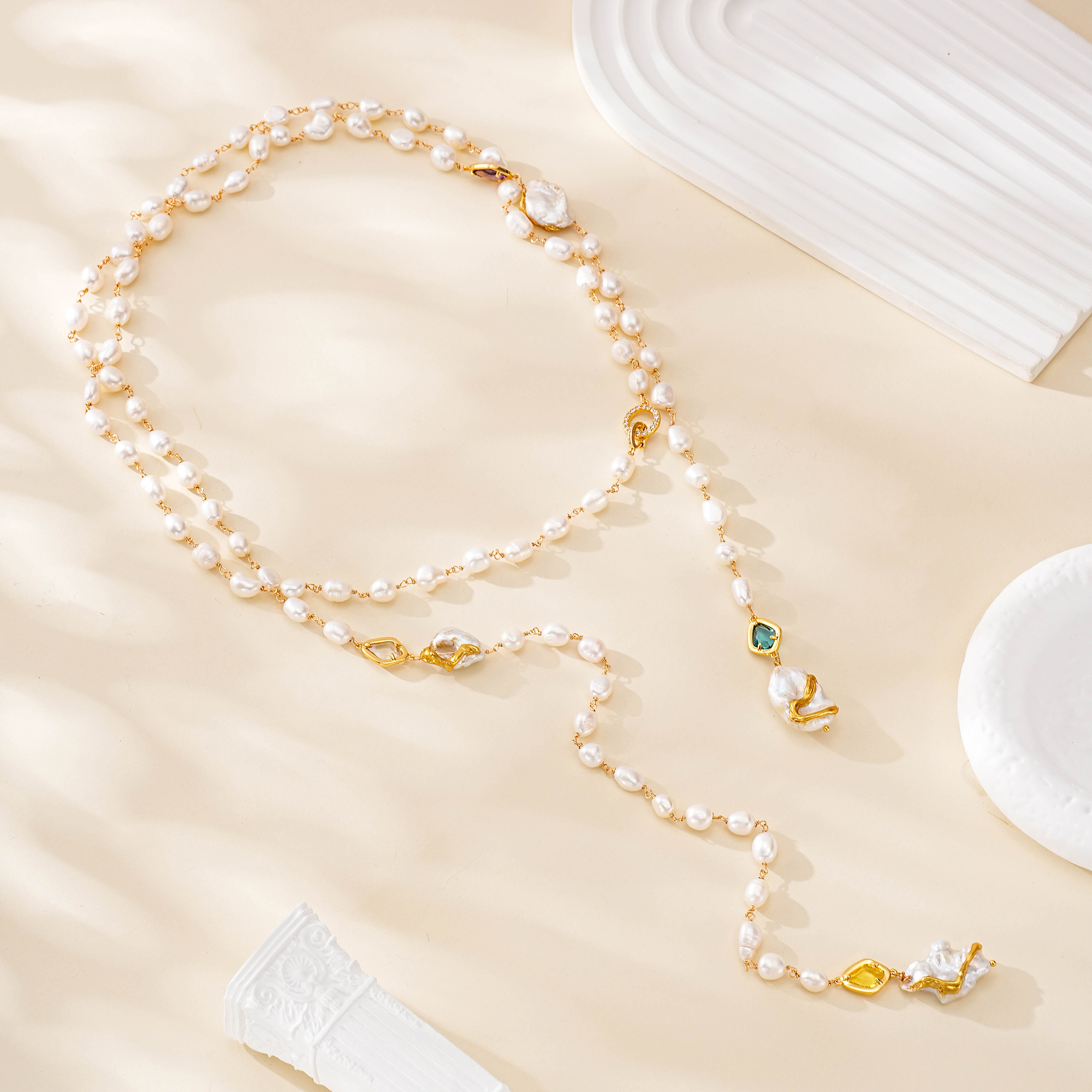 Full flat lay of extra-long freshwater pearl and colorful gemstone necklace
