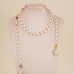 Long freshwater pearl necklace displayed on a neutral bust