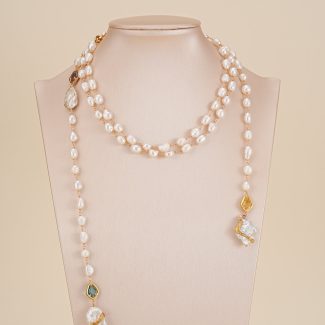 Long freshwater pearl necklace displayed on a neutral bust