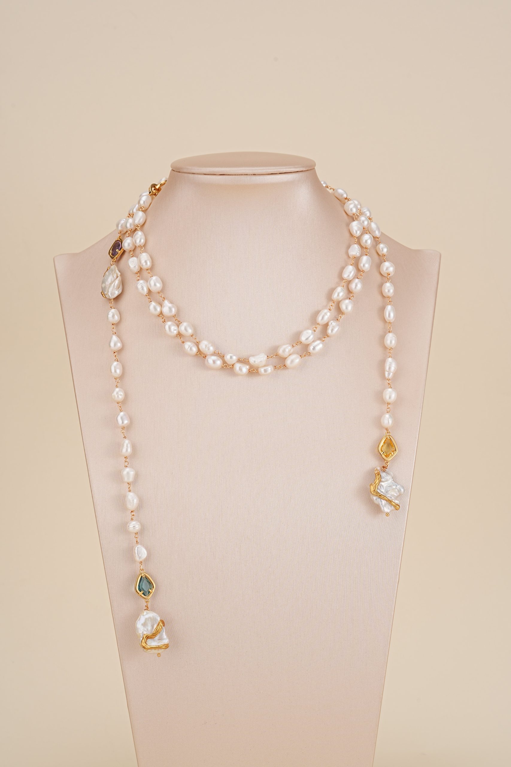 Long freshwater pearl necklace displayed on a neutral bust