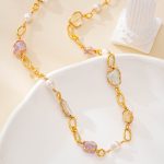 Detailed view of irregular stones and pearls along gold-toned links