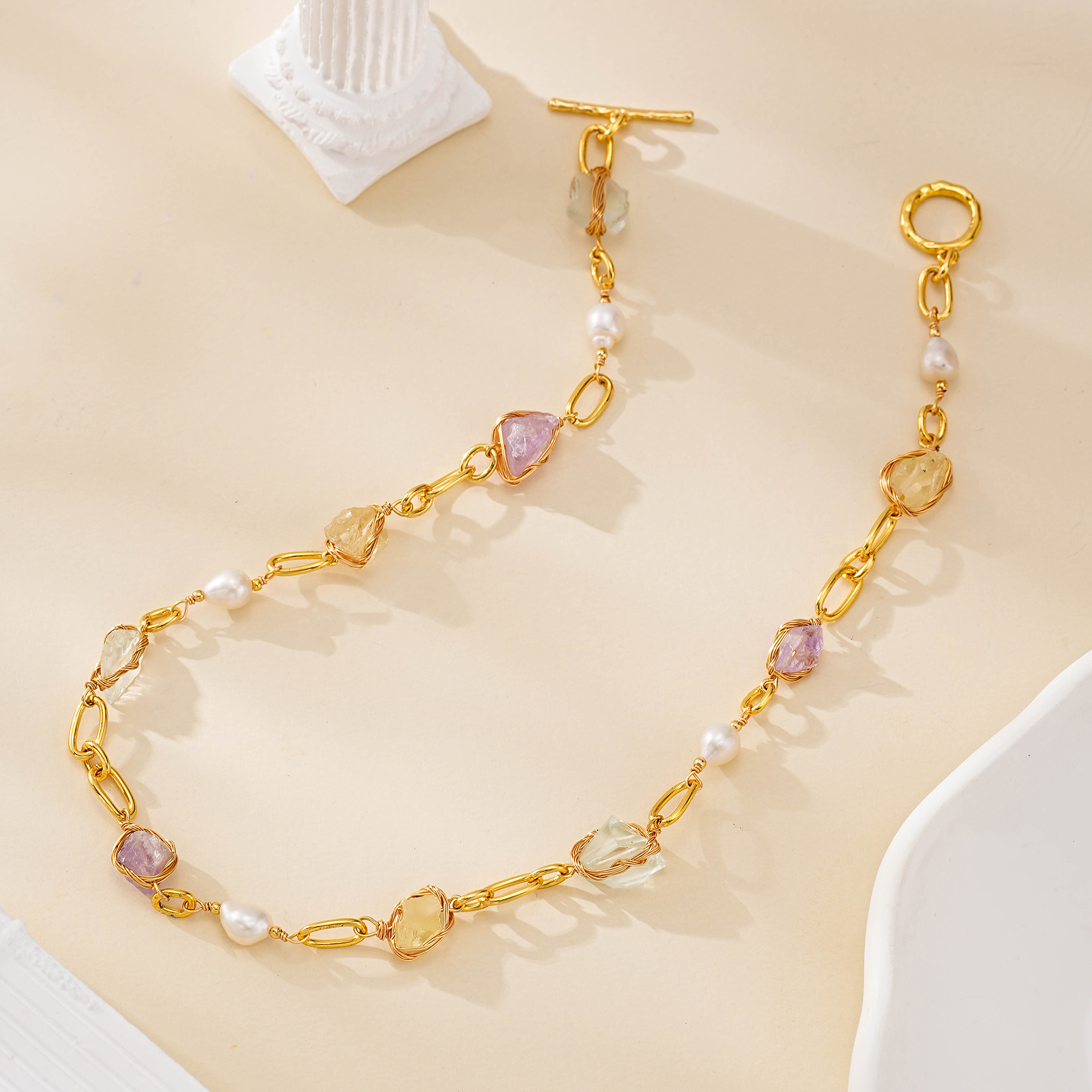 Full flat lay of colorful gemstone and pearl oval link necklace