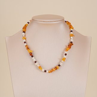 Amber-toned gemstone and baroque pearl necklace on a neutral bust