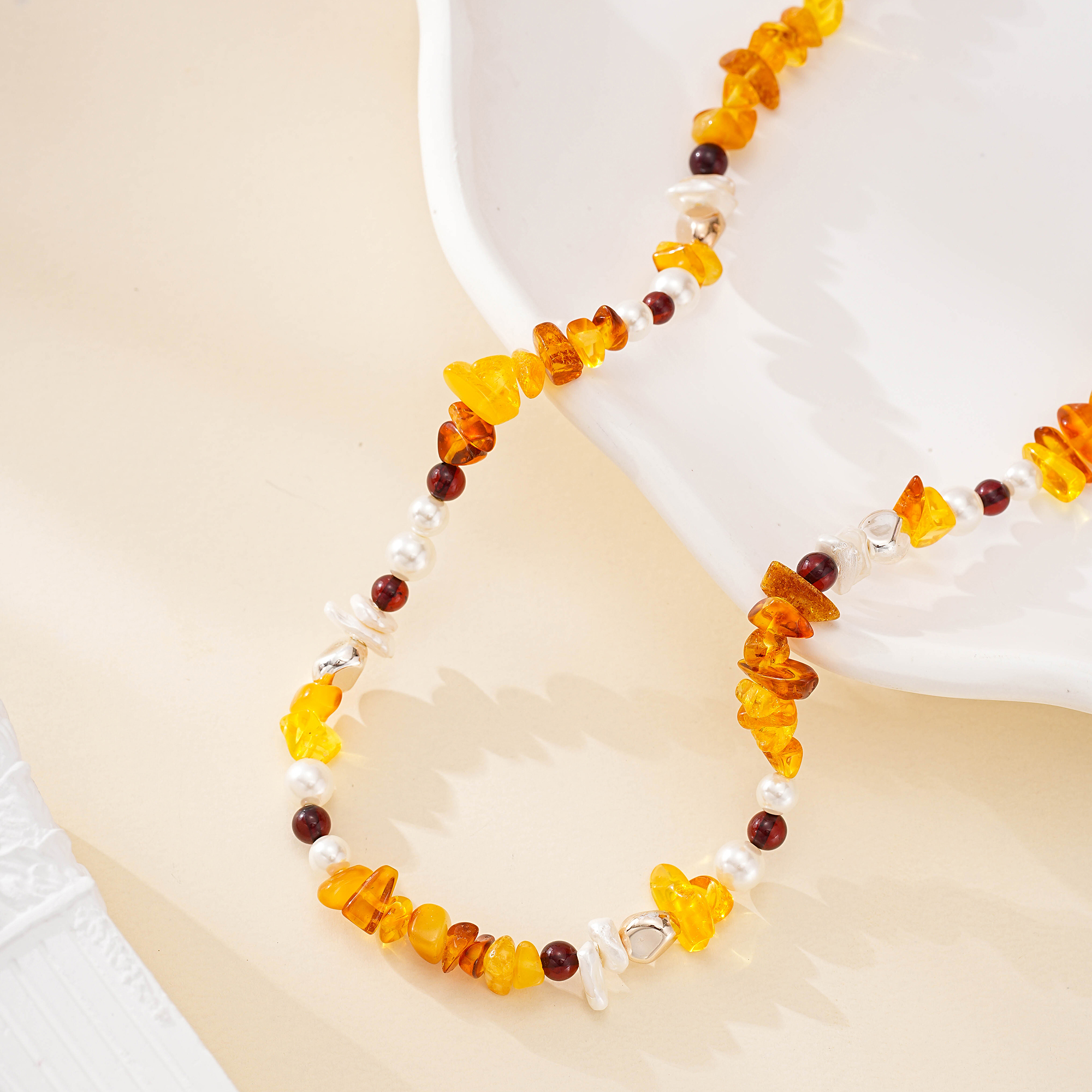 Detail of warm gemstone chips, dark beads and irregular white pearls