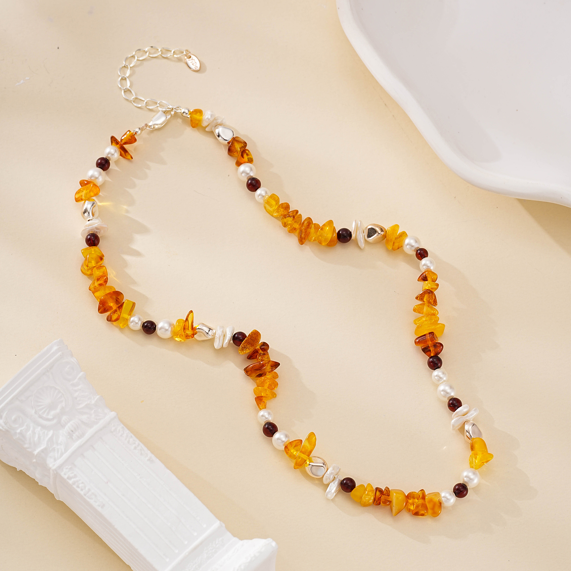 Necklace arranged in a loose loop showing alternating gemstones and pearls
