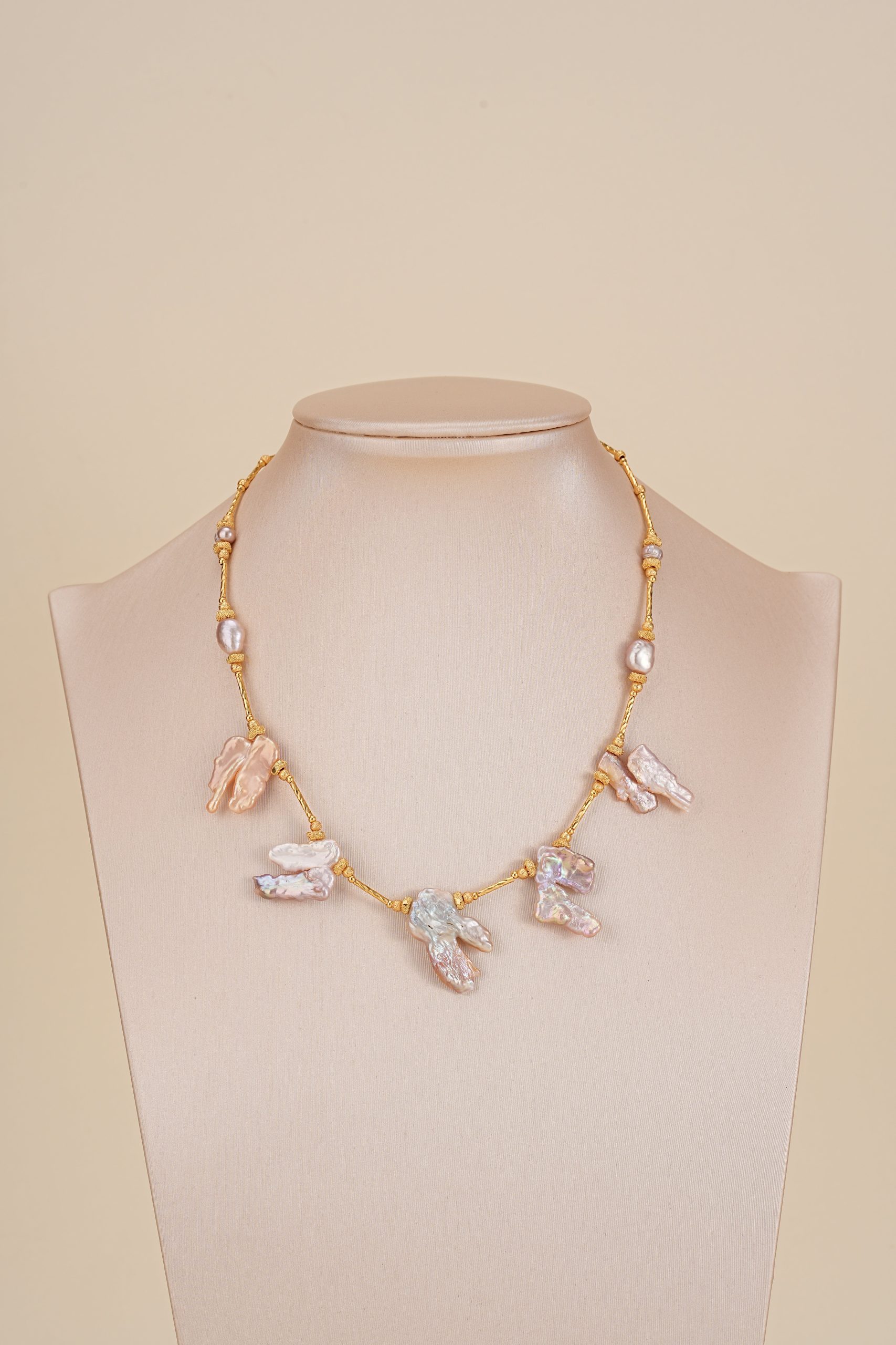 Blush baroque pearl fringe necklace displayed on a neutral bust