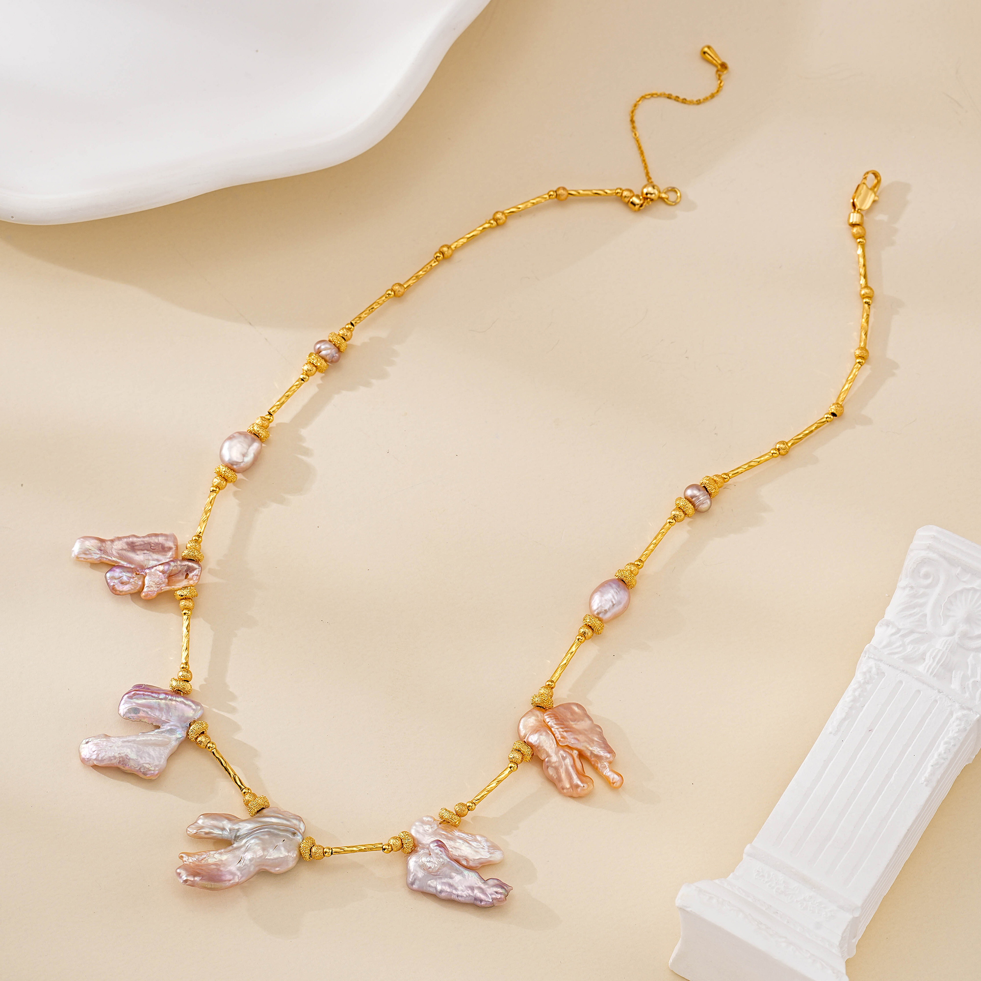 Full flat lay of blush baroque pearl necklace with sculptural drops