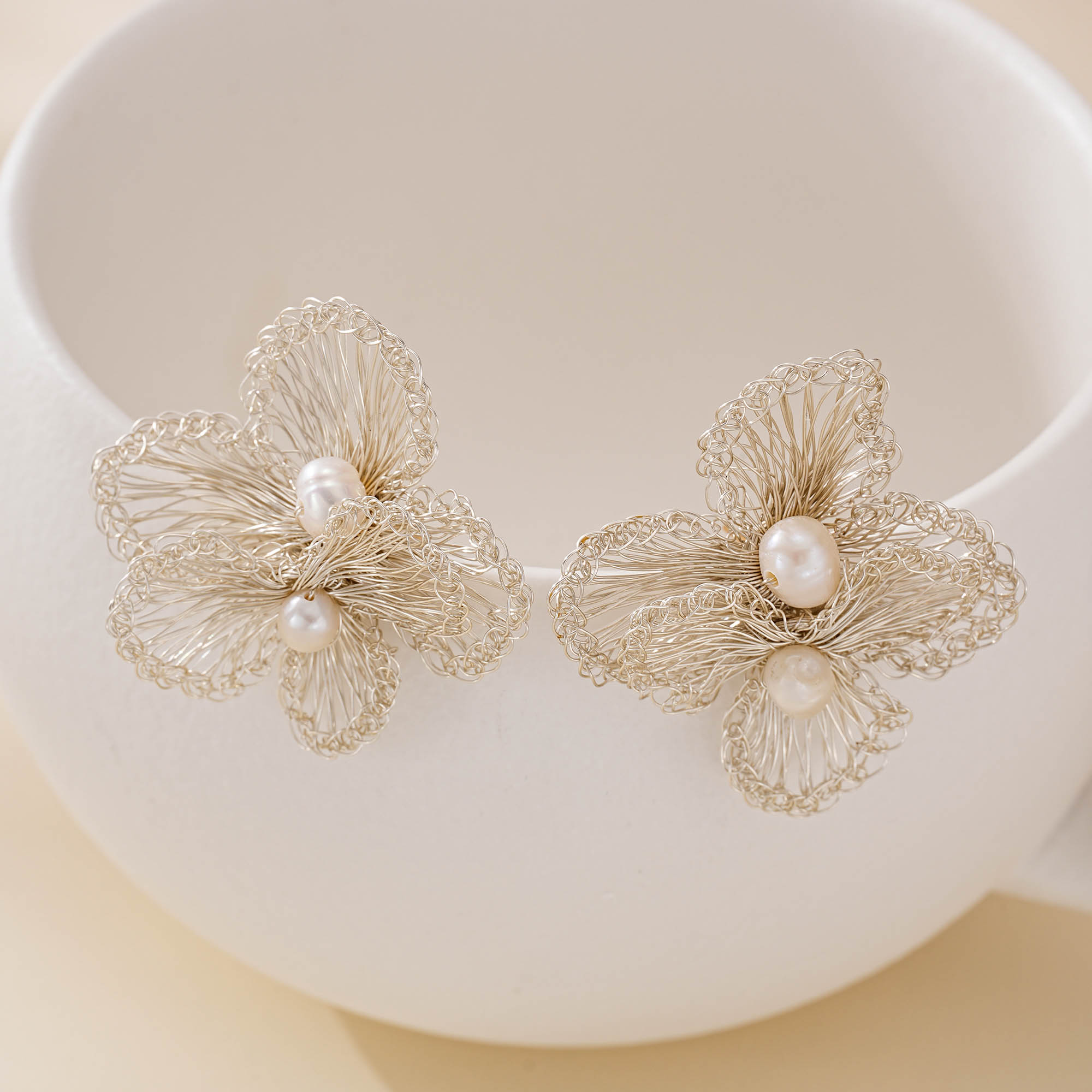 Openwork silver-toned wire flower earrings with two white freshwater pearls on each earring