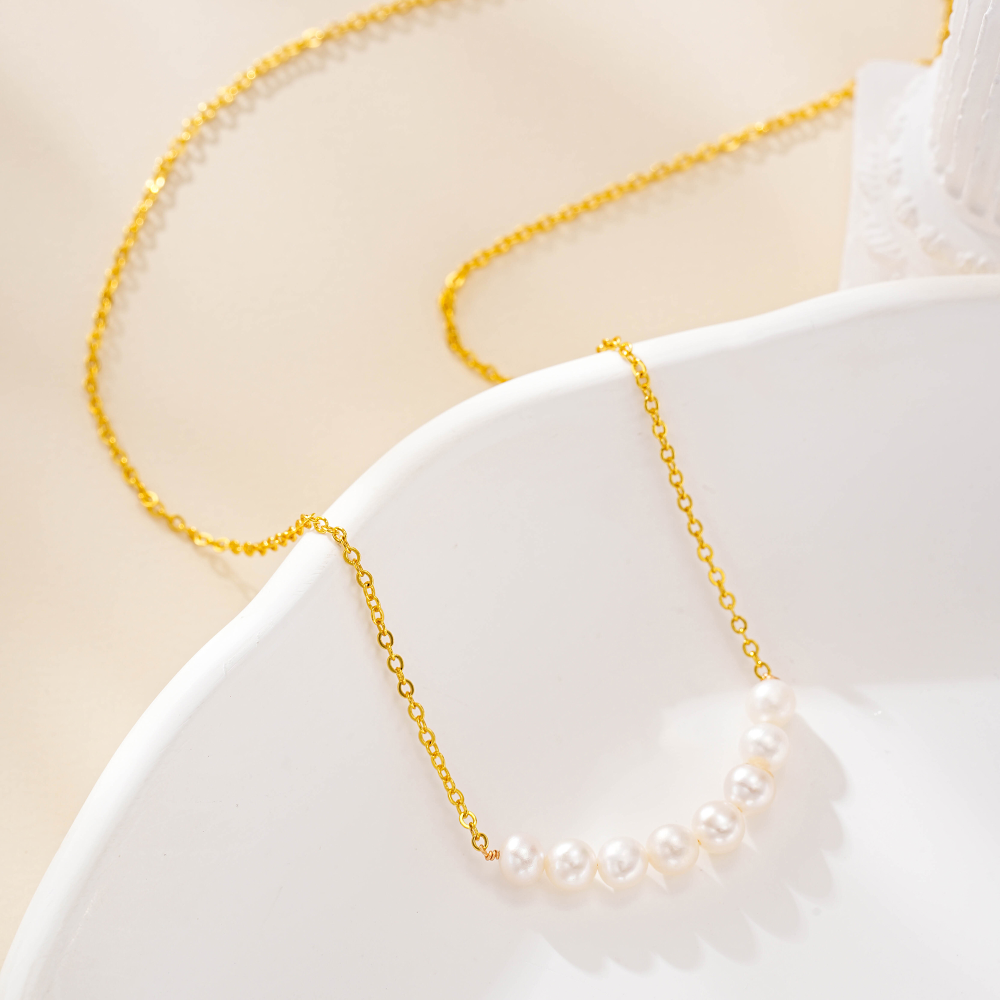 Close-up of the clustered-pearl necklace on a white dish