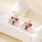 White pearl petals surrounding a purple center pearl and dark beads