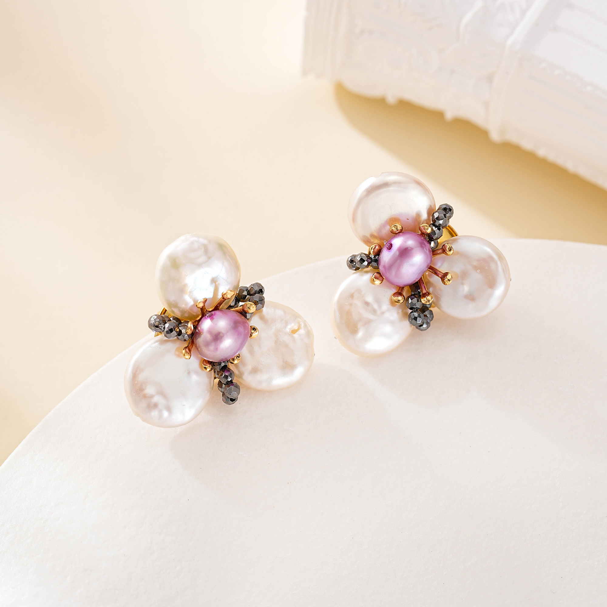 Pair of floral pearl stud earrings with black spinel accents