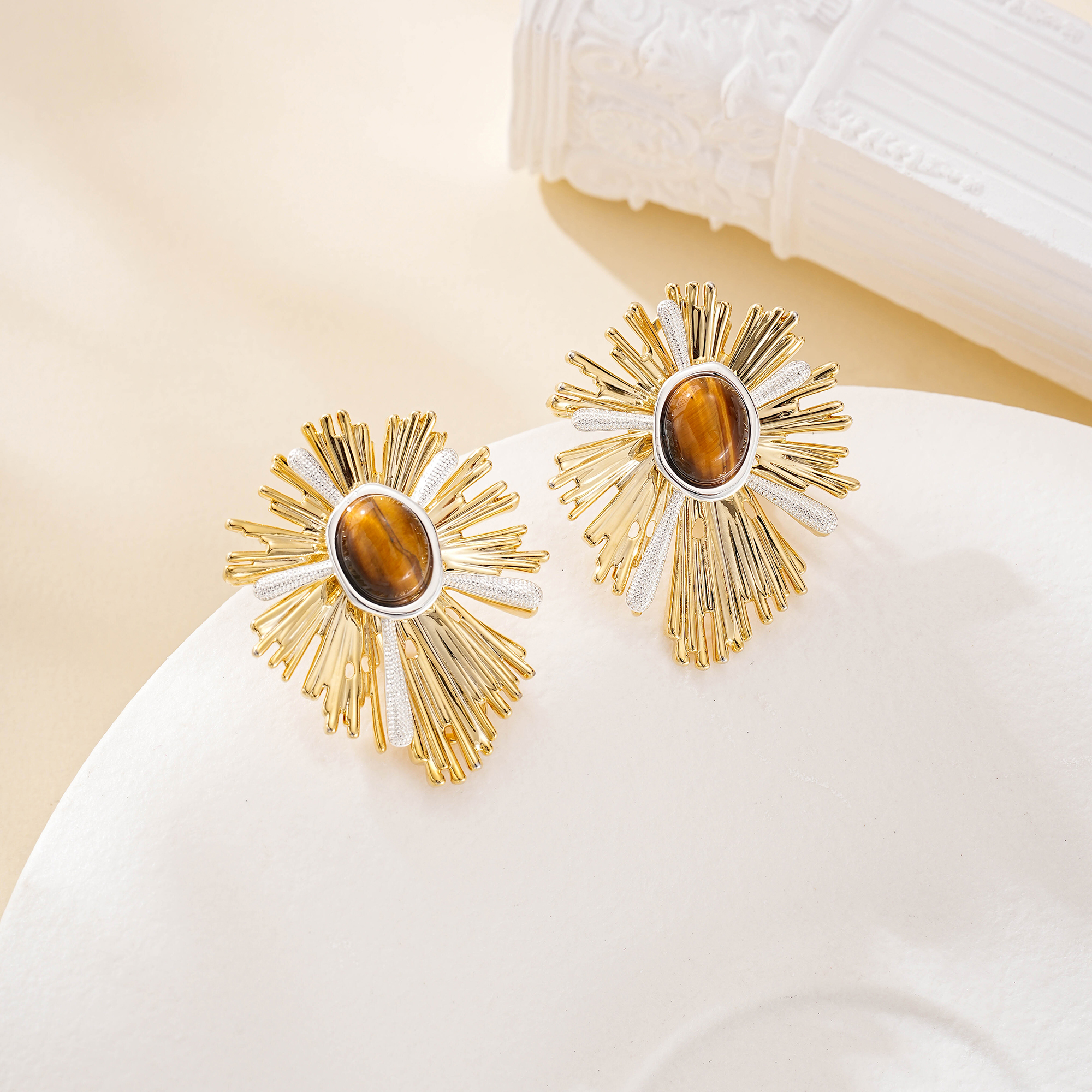 Oval brown tiger's eye stones within gold-tone sunray earrings