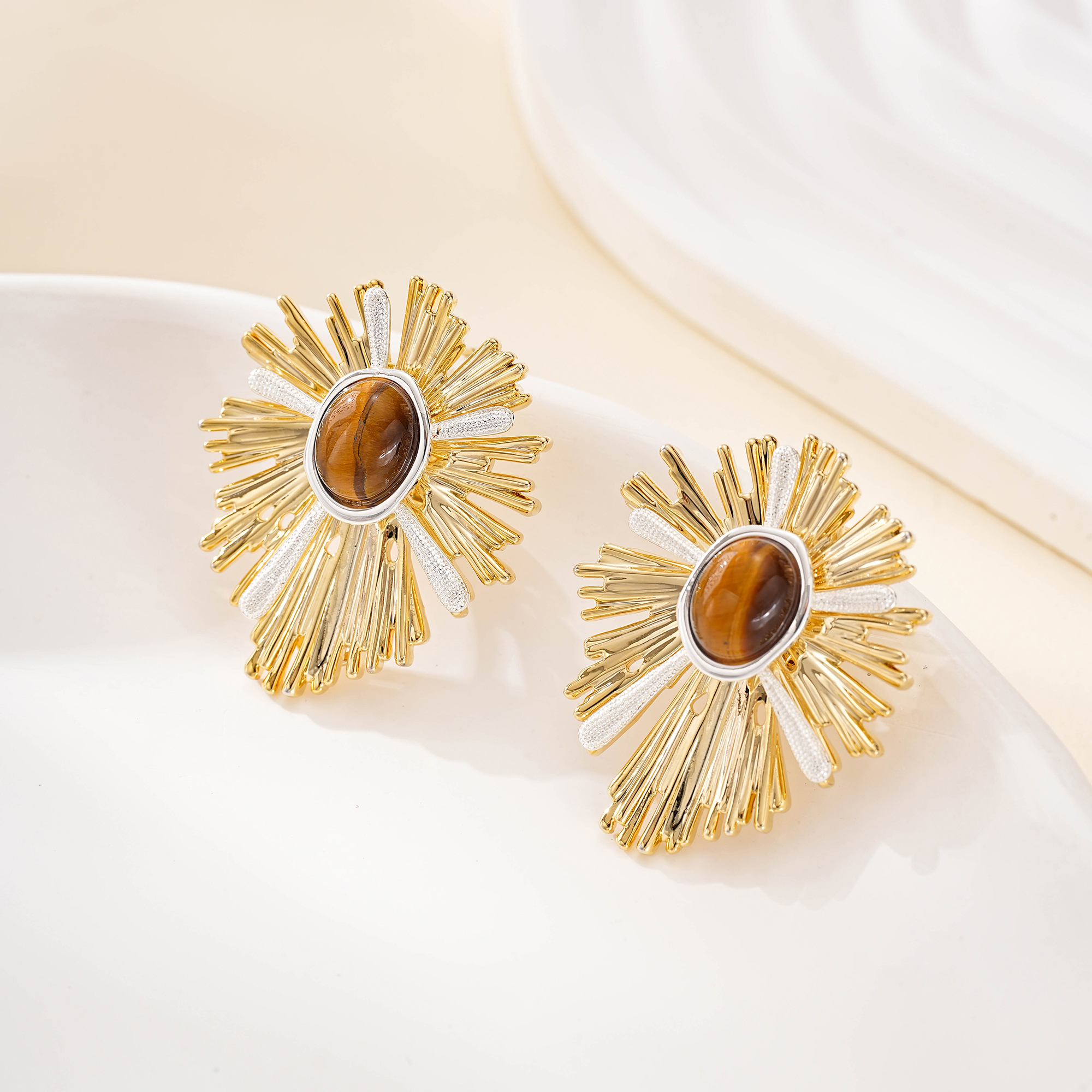 Close view of the oval tiger's eye and textured sunburst metalwork