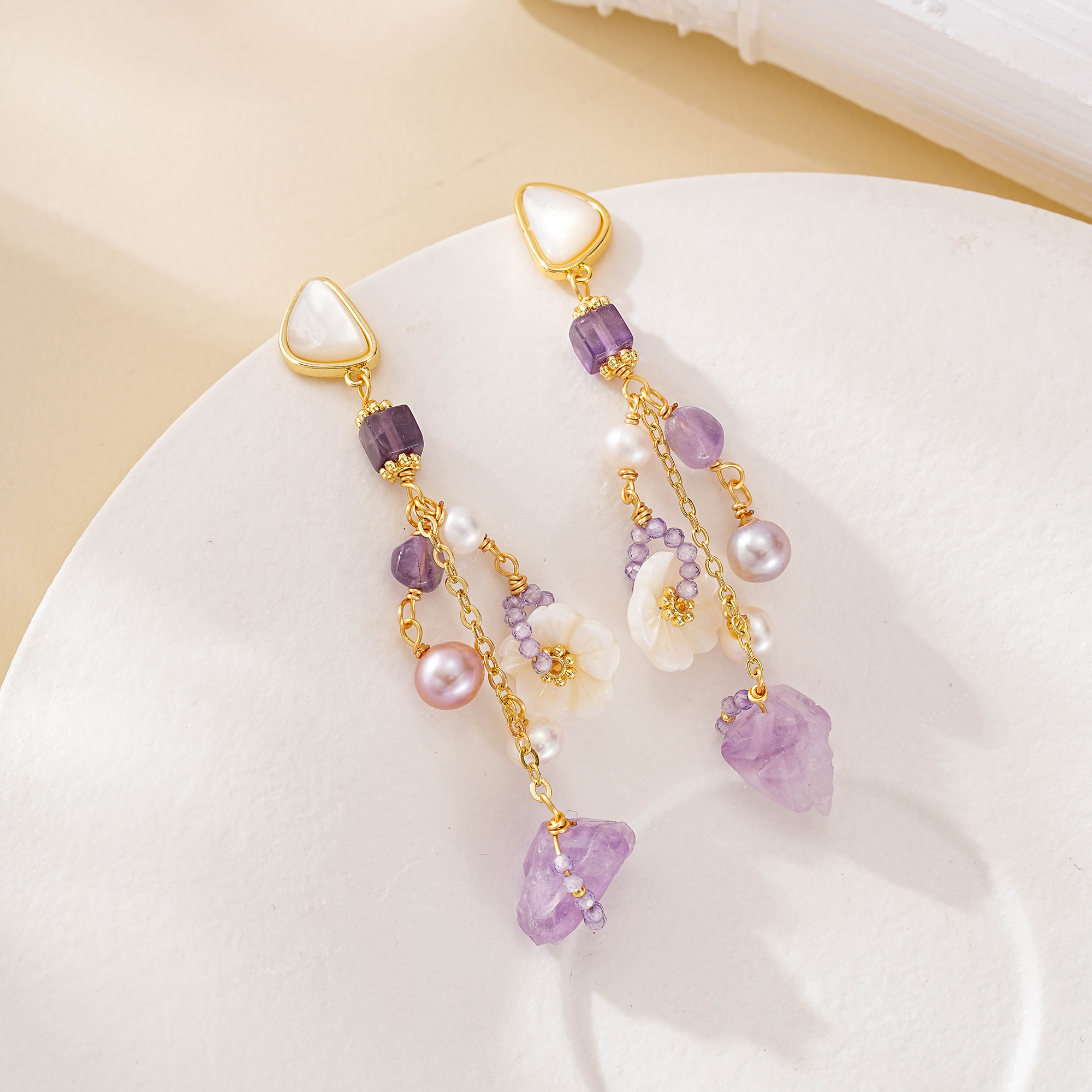 White carved flowers amid amethyst and freshwater pearl tassels