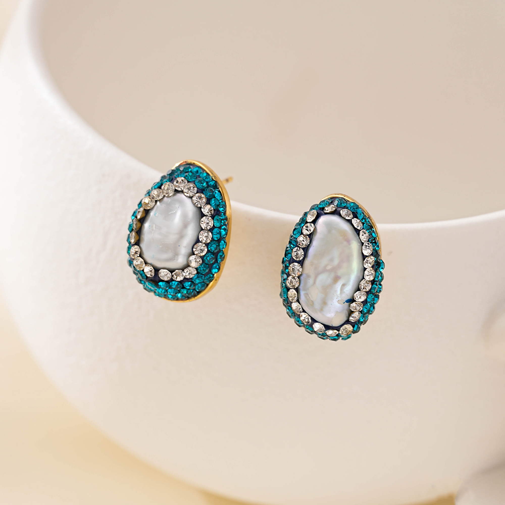 Baroque pearl stud earrings with green and clear stone halos
