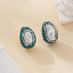 Oval baroque pearls surrounded by teal-green and clear sparkling accents