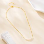 Gold-tone necklace with a centered row of eight pearls