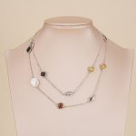 Long silver-tone pearl and resin necklace on display bust