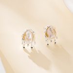 Silver-plated copper stud earrings with a baroque pearl in a molten metal setting